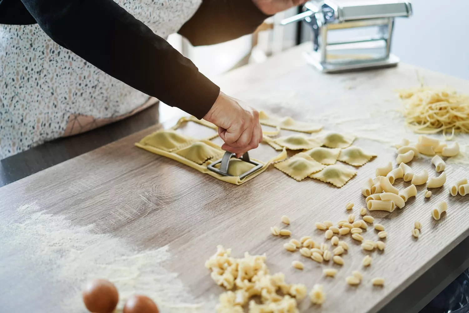 Femme préparant des raviolis frais dans une fabrique de pâtes - Focus sur la main au centre