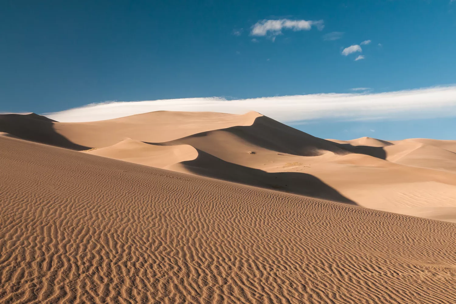 Impressive Sand Dunes with clouds and blue sky, seen in Great Sand Dunes National Park, Colorado, USA.