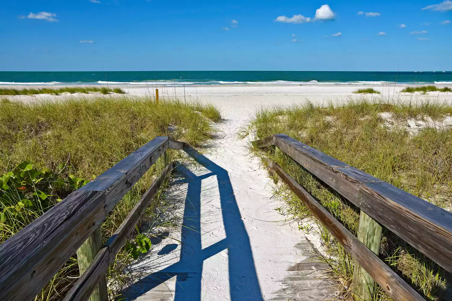 Passerelle en bois menant à la plage de sable blanc sur l'île Anna Maria