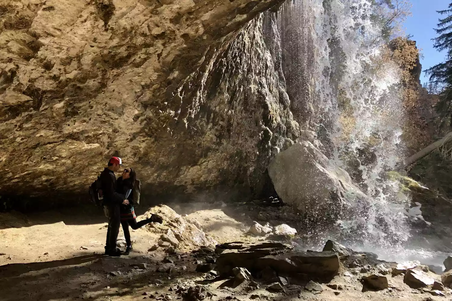 A couple underneath the waterfall at Hanging Lake in Glenwood Springs, Colorado