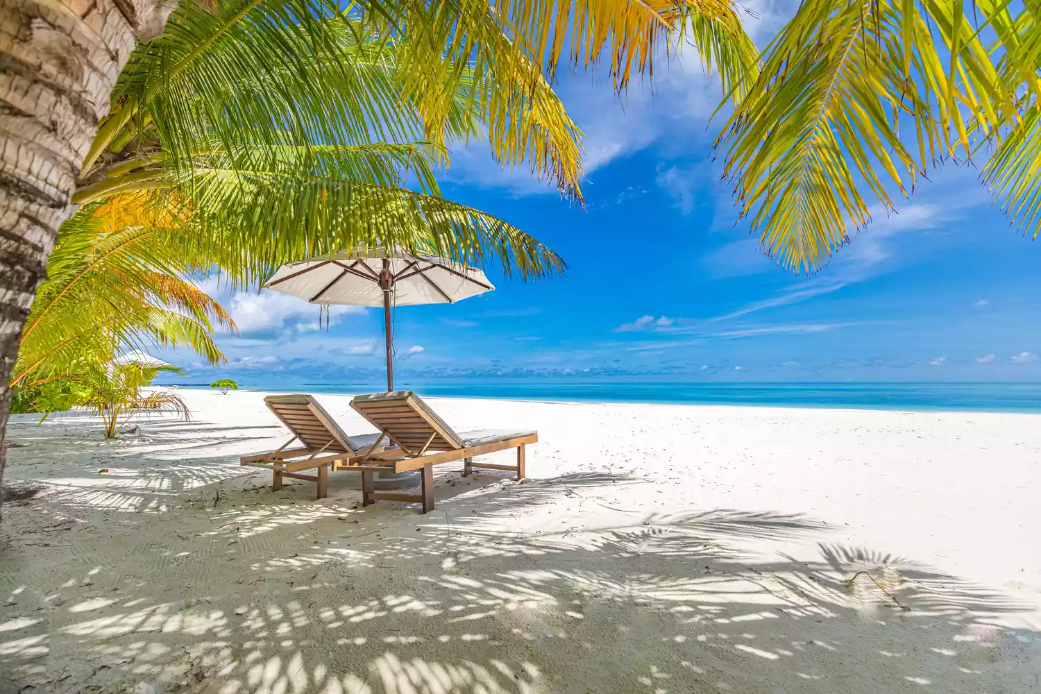 Deux chaises de plage sous un parasol sur une plage des Bahamas