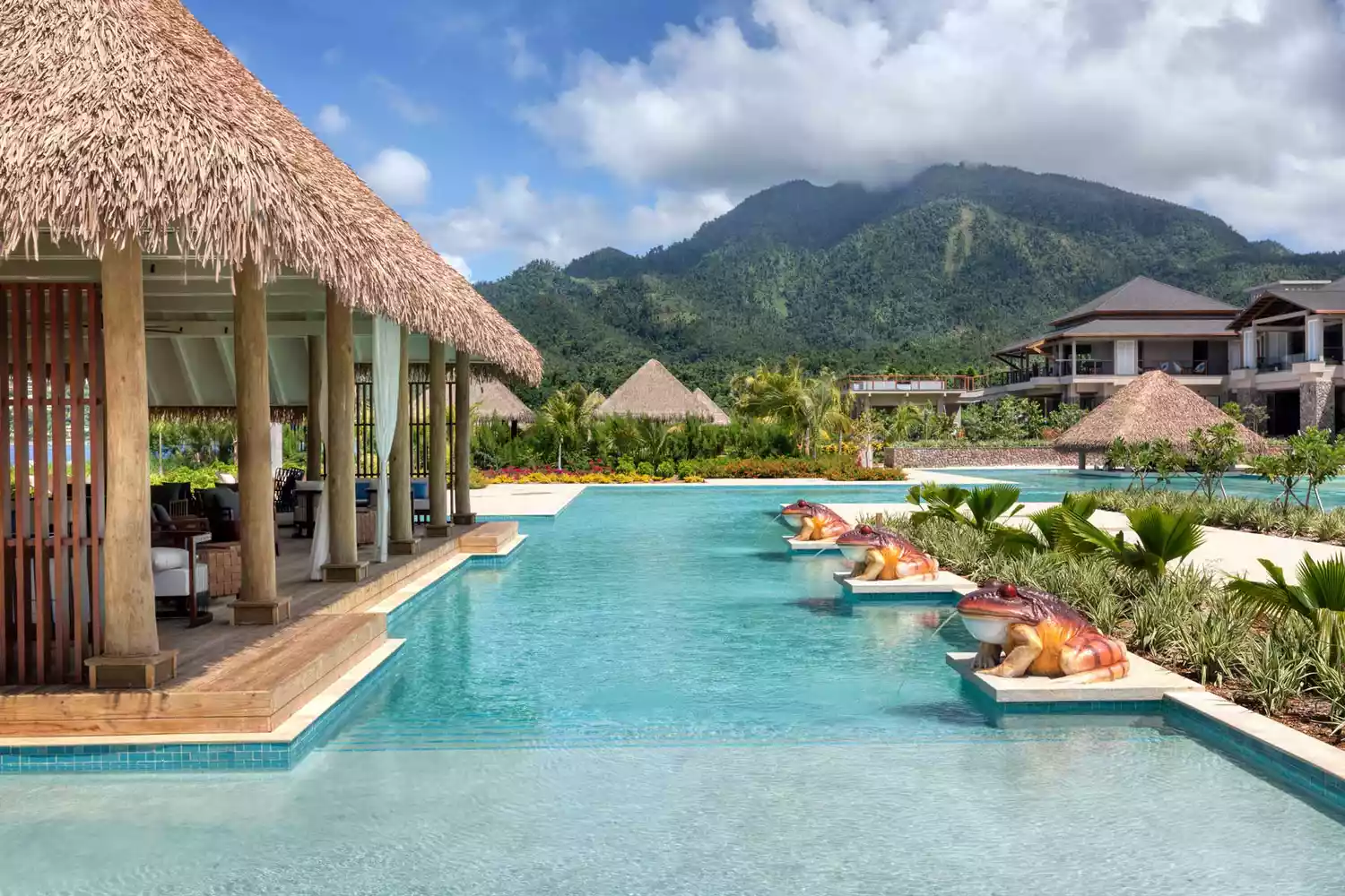 View of pool with frog statues and mountains in the background