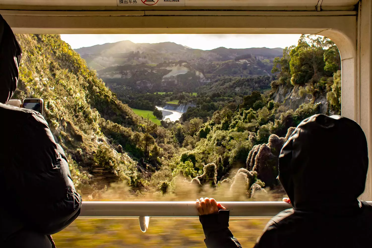 Passengers on board the Norther Explorer train admiring the view of Kawhatau Valley in New Zealand 