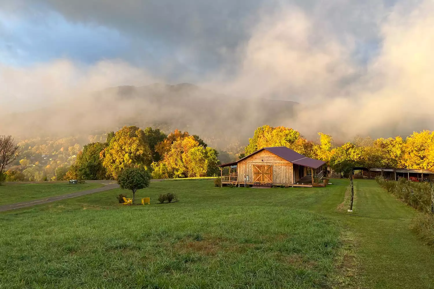 Vapeur des sources chaudes s'élevant au-dessus d'une grande cour avec une grange d'événements à Broadwing Barn