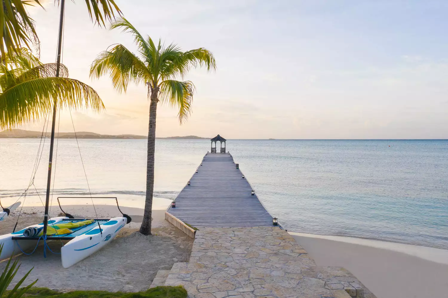 Long dock overwater and a catamaran boat by the sea at Jumby Bay Island resort