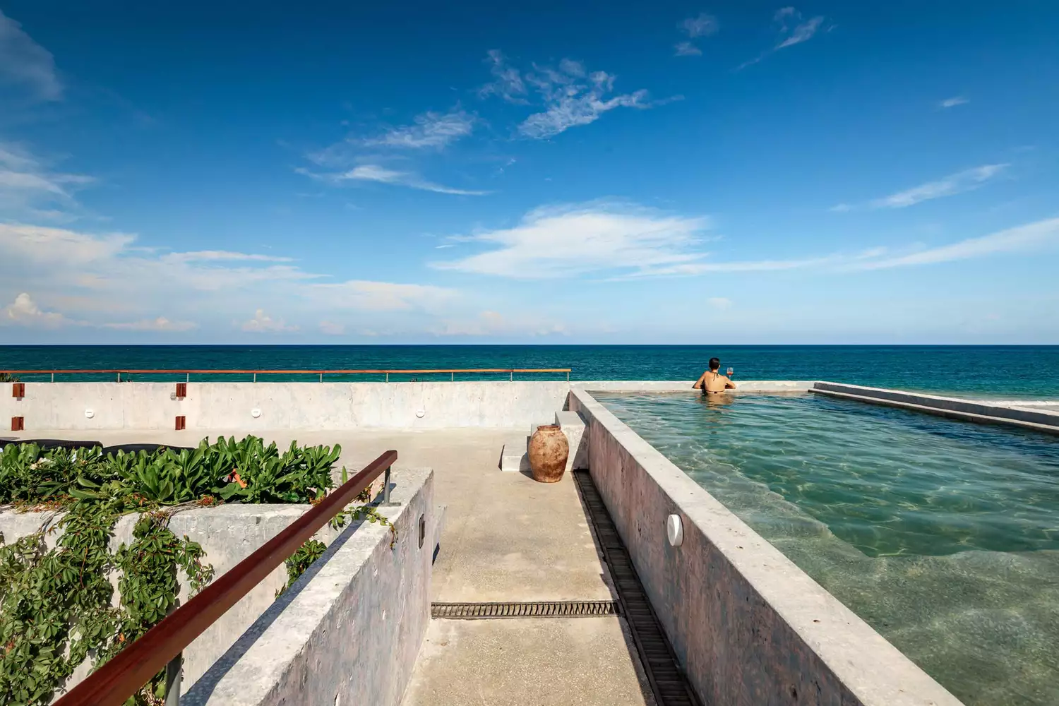 Un homme profitant de la vue depuis la piscine de Casa Bautista à Riviera Maya