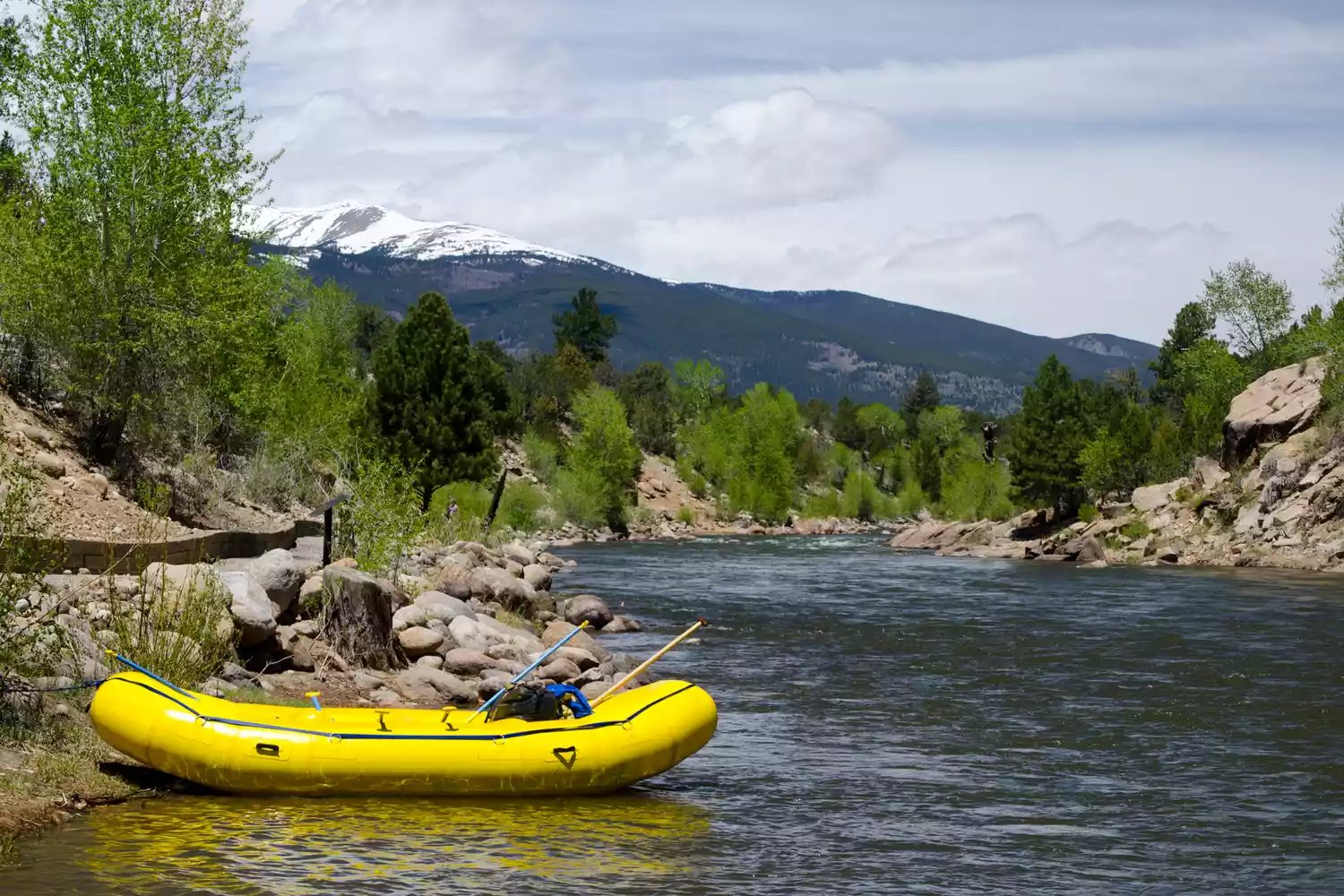 Un radeau jaune est posé sur le bord de la rivière Arkansas à Buena Vista, Colorado.