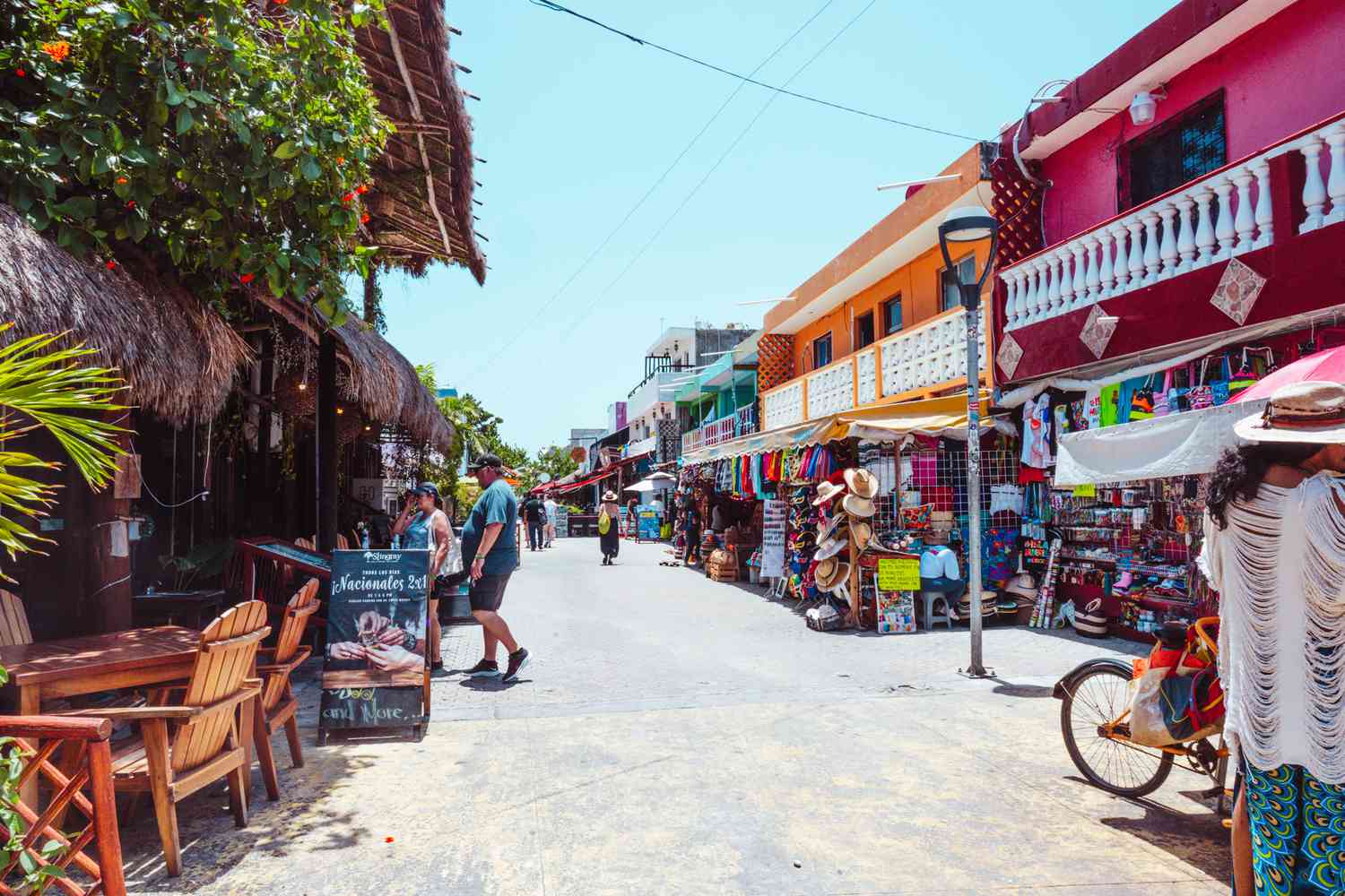 People walking down a street lined with beautiful buildings of Isla Mujeres town