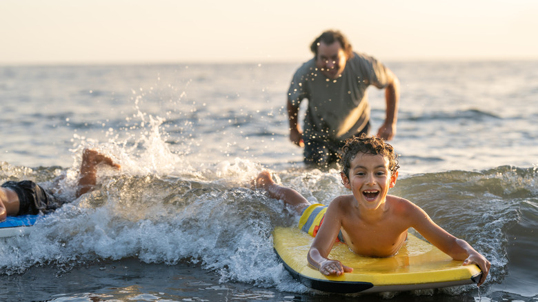 man with body boarding boy