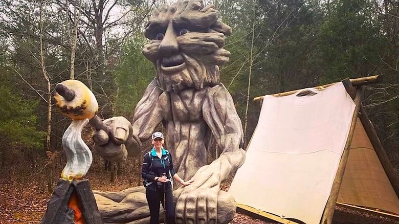 Sculpture en bois près d'une tente improvisée