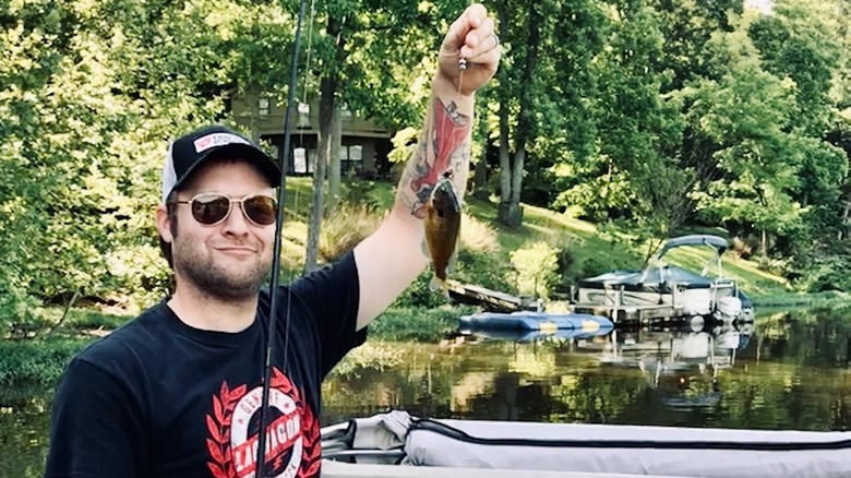 Homme montrant son poisson attrapé